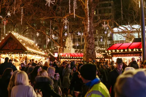 Um grupo de pessoas reúne-se no Mercado de Natal de Leicester Square