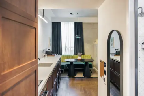 Aparthotel Kitchen perfect for bleisure travellers, a green couch hugs the corner of a kitche.