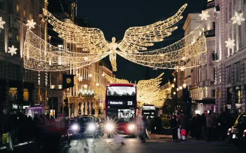 Um autocarro vermelho de Londres debaixo das Luzes de Natal da Oxford Street